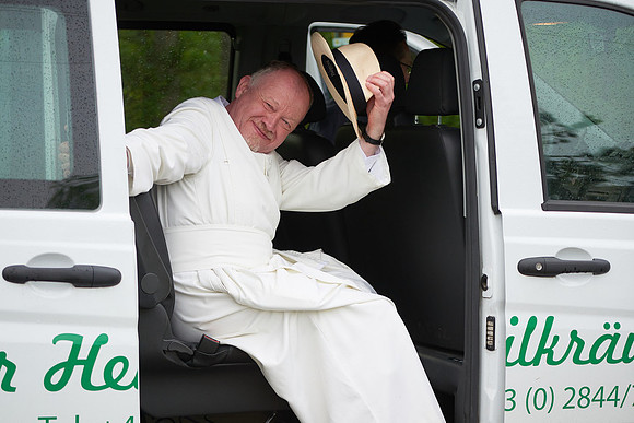 Kräuterpfarrer Benedikt im Auto sitzend