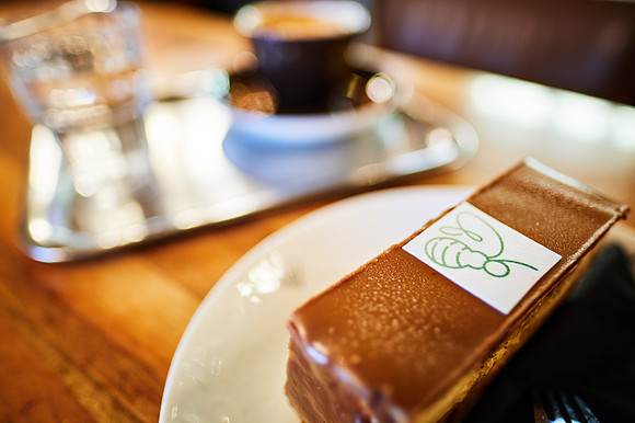 eine Melange und eine Hummelschnitte auf dem Tisch