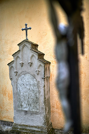 ein Grabstein mit Kreuz im Vordergrund