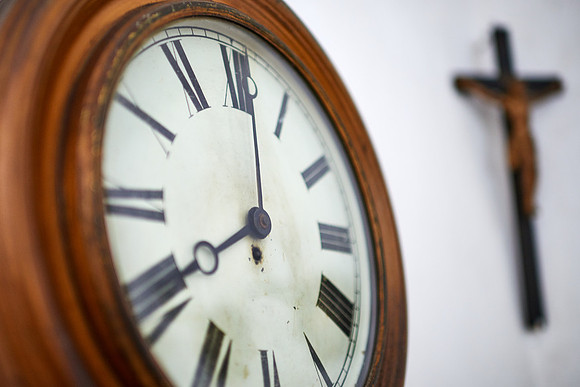 eine Wand mit Uhr und einem Kreuz